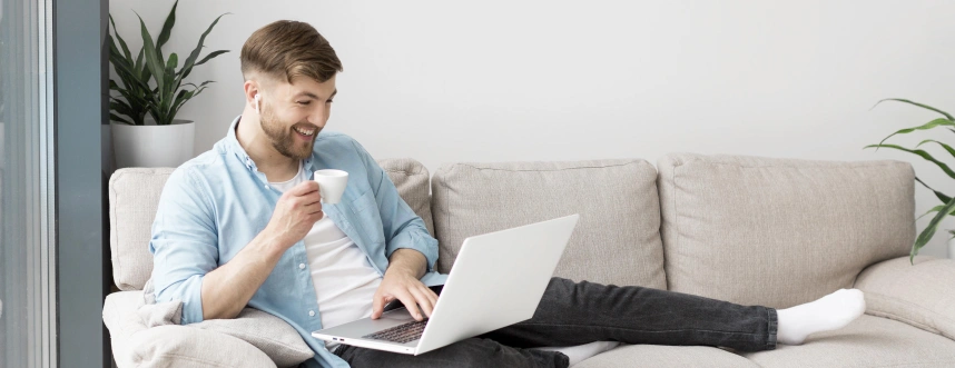 smiley-man-drinking-coffee-using-laptop